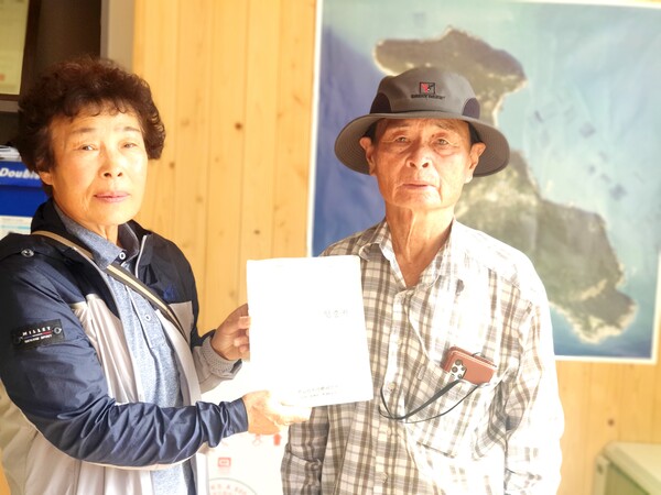 사진은 소안면 당사리 김미화 이장과 최민재 노인회장이 1990년에 마을과 주민 간 장수도 임대 계약한 공증 문서를 들고 있는 모습이다.
